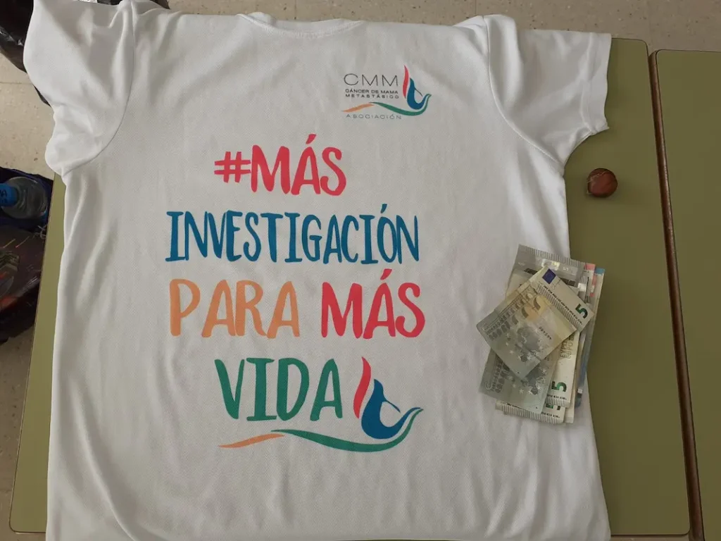 Fotografía de la camisa de AECMM con dinero de la donación